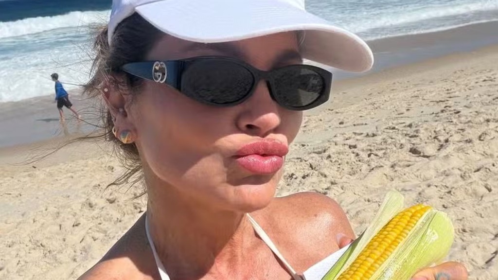 Em dia de praia, Flávia Alessandra aproveita para saborear milho verde à beira-mar